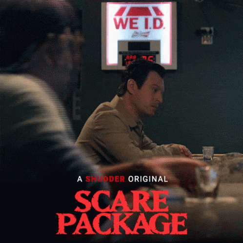 A Poster For The Movie Scare Package Shows Two Men Sitting At A Bar GIF