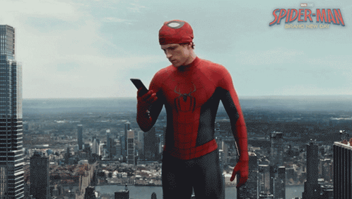 A Poster For The Movie Spider-Man Shows A Man In A Suit Looking At His Phone GIF