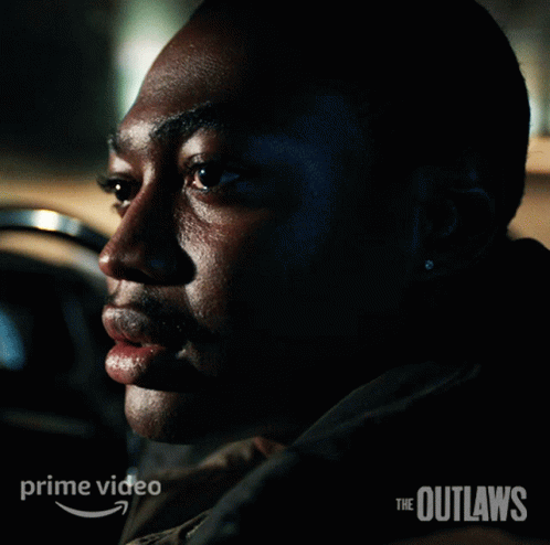 A Poster For The Outlaws Shows A Man Sitting In A Car GIF