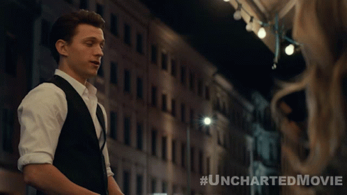 A Poster For The Uncharted Movie Shows A Man In A Suit And Vest GIF
