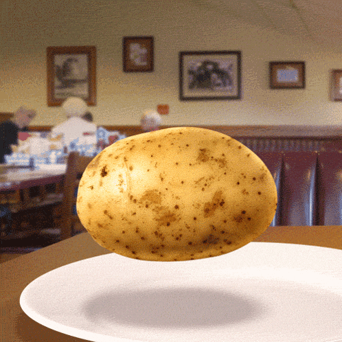 A Potato Is Floating On A White Plate GIF