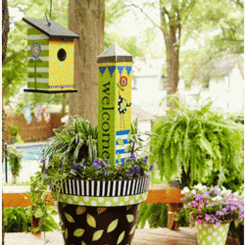 A Potted Plant With A Welcome Sign Hanging From It GIF