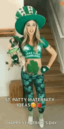 A Pregnant Woman In A Leprechaun Costume Is Standing On A Set Of Stairs Holding A Dog . GIF