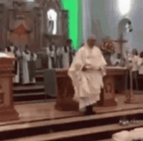A Priest Is Walking Down The Aisle Of A Church With A Green Light Behind Him . GIF