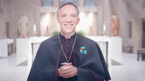 A Priest Wearing A Blue Cape With A Cross On His Chest GIF