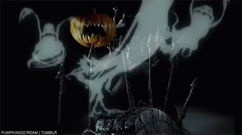 A Pumpkin With A Bat On It 'S Face Is Surrounded By Ghosts In A Dark Room . GIF