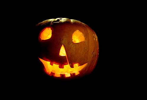 A Pumpkin With A Face Carved Into It Is Lit Up GIF