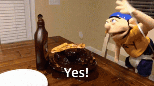 A Puppet Is Sitting At A Table With A Plate Of Food And A Bottle Of Ketchup And The Words Yes On The Table GIF