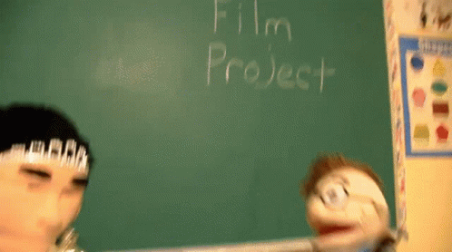 A Puppet Is Standing In Front Of A Blackboard That Says Film Project GIF