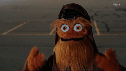 A Puppet With A Beard And Big Eyes Is Wearing A Helmet GIF