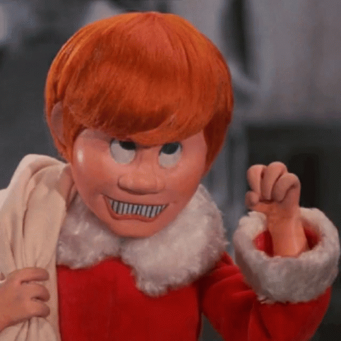 A Puppet With Red Hair And A White Collar Is Wearing A Mask GIF