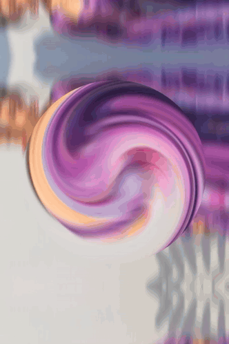 A Purple And Orange Swirl On A Gray Surface GIF