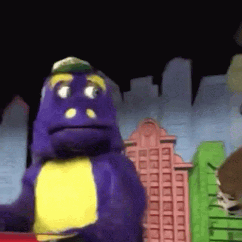 A Purple Dinosaur With A Yellow Chest Is Standing In Front Of A Cityscape . GIF