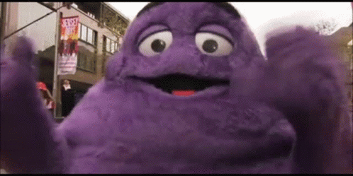 A Purple Mcdonald 'S Character Is Standing In Front Of A Street Sign That Says Street Art GIF