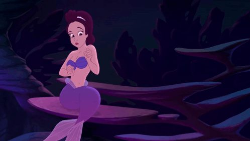 A Purple Mermaid Is Sitting On A Rock In A Dark Cave GIF