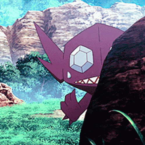 A Purple Monster With A Diamond In Its Eye Is Standing Next To A Large Rock . GIF
