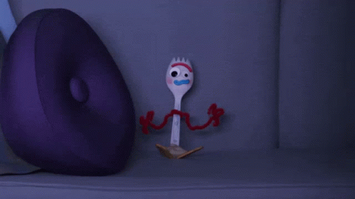 a purple pillow sits next to a toy fork from toy story
