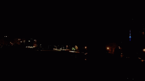 A Purple Sky With A Few Clouds And A Tower In The Distance GIF