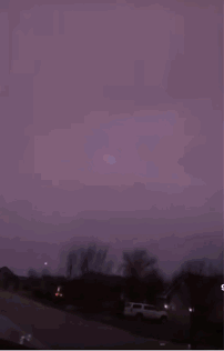 A Purple Sky With Lightning Strikes In The Distance GIF