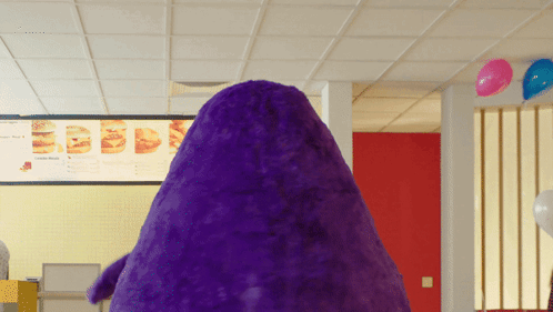 A Purple Stuffed Animal In Front Of A Menu GIF