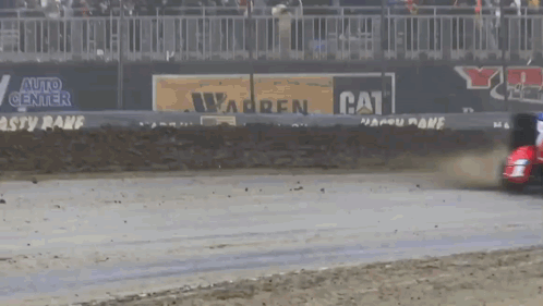 A Race Car Is Driving Down A Track With A Cat Advertisement In The Background GIF