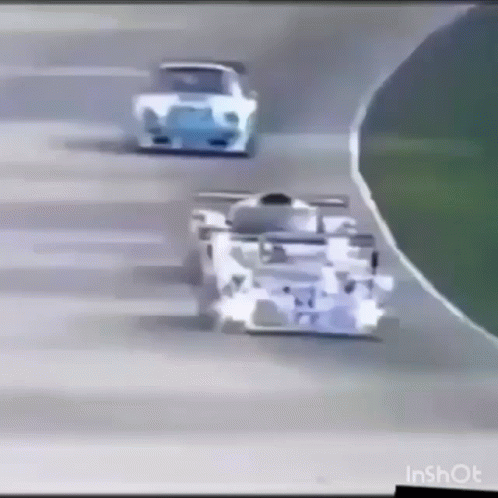 A Race Car Is Driving Down A Track With Other Cars Behind It . GIF