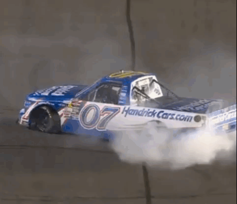 A Race Car With The Number 07 On It Is Driving Down A Track . GIF