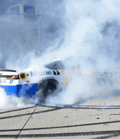 A Race Car With The Number 67 On It Is Smoking GIF
