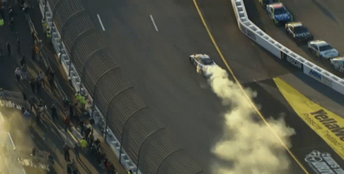 A Race Track With The Word Geico On The Side Of It GIF