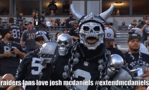 A Raiders Fan Wearing A Skull Mask And Horned Helmet GIF