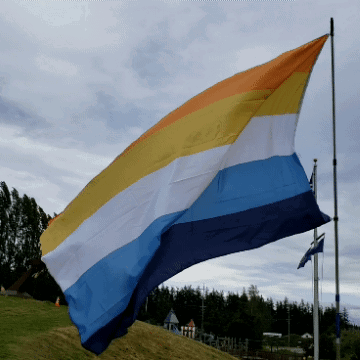 A Rainbow Colored Flag Is Flying In The Wind GIF