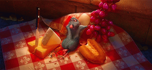 A Rat Is Sitting On A Checkered Table Cloth Next To A Bunch Of Grapes GIF
