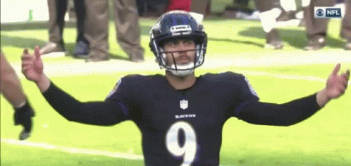 a ravens football player with his arms outstretched on the field