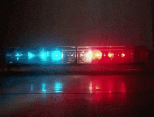 A Red And Blue Police Light Is Sitting On The Floor GIF