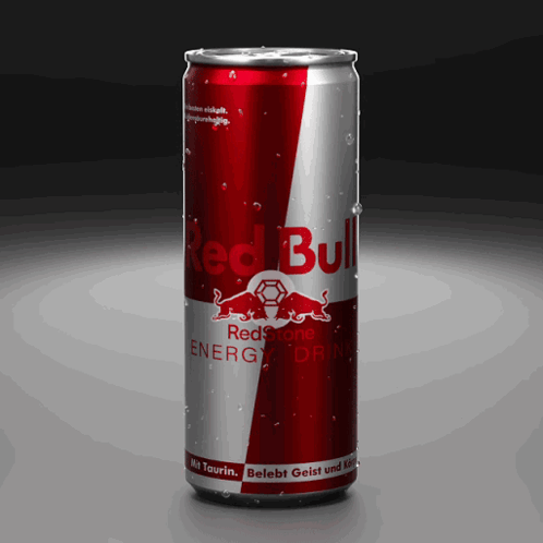 A Red And Silver Can Of Red Bull Energy Drink On A Black Background GIF