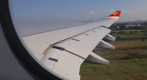 A Red And White Airplane Wing With A Yellow Star On The Tail GIF