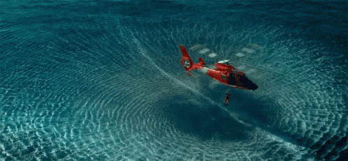 A Red And White Helicopter Is Floating In The Ocean GIF