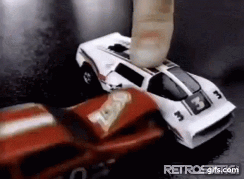 A Red And White Toy Car Is Being Smashed By A Finger . GIF