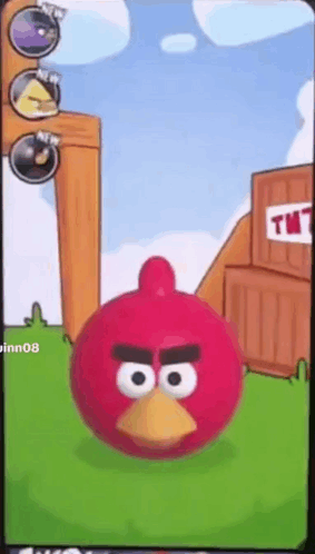 A Red Angry Bird Is Standing In Front Of A Tnt Building GIF