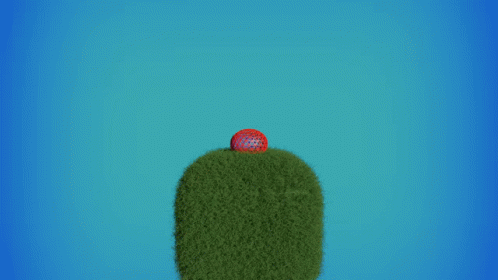 A Red Ball Is Flying Through The Air Over A Green Hill GIF