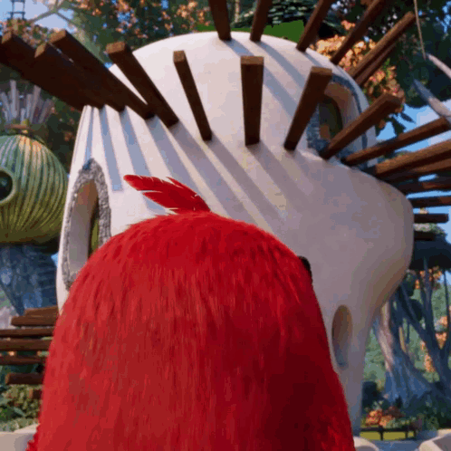 Red Bird Standing In Front Of White Building GIF
