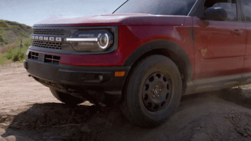 A Red Bronco Is Driving Through The Dirt On A Dirt Road GIF