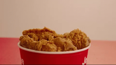 a red bucket filled with fried chicken has the word jc on it