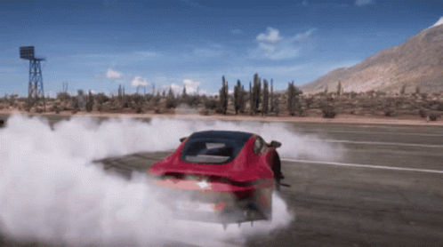 A Red Car Is Drifting On A Desert Road With Mountains In The Background GIF