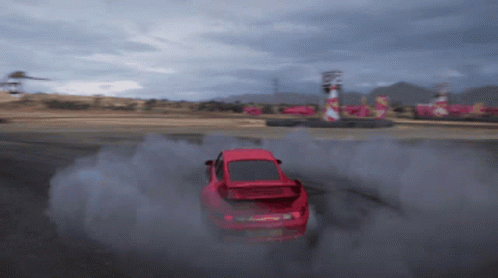A Red Car Is Drifting On A Track And Smoke Is Coming Out Of It GIF