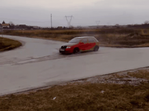 A Red Car Is Driving Down A Road In The Rain GIF
