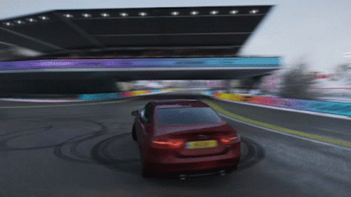 a red car is driving down a road with a yellow license plate that says ' a '
