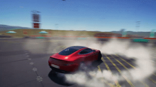 A Red Car Is Driving Down A Road With Smoke Coming Out Of The Tire GIF