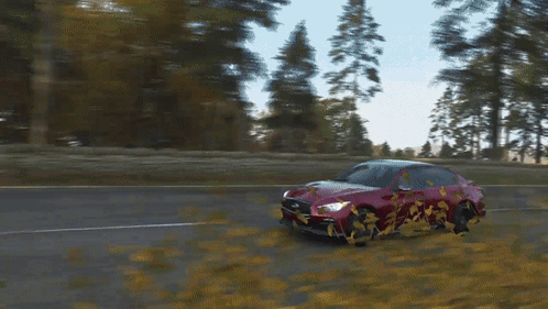 A Red Car Is Driving Down A Road With Trees Behind It GIF
