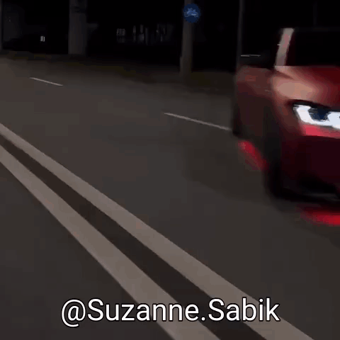 A Red Car Is Driving Down A Street With The Words @Suzanne.sabik Written On The Bottom GIF